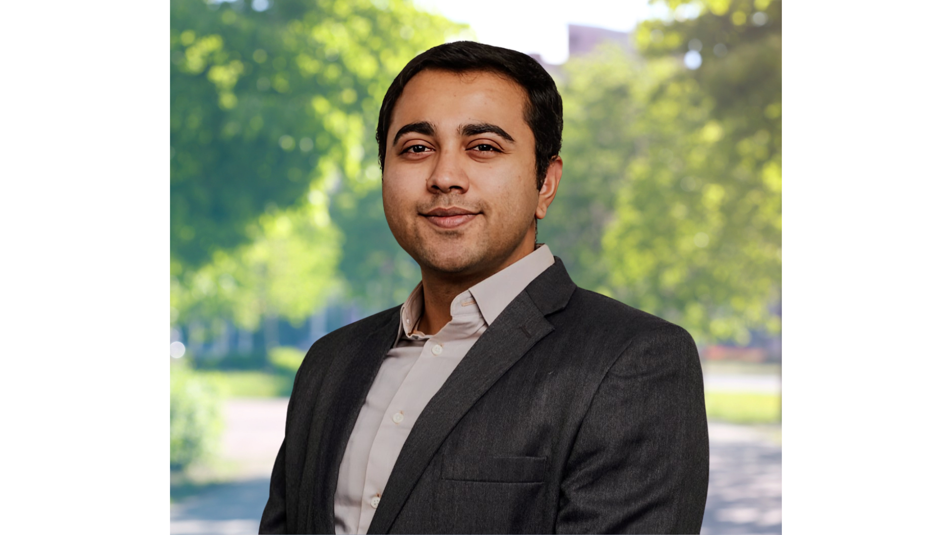 Headshot of man in suit, outdoors.