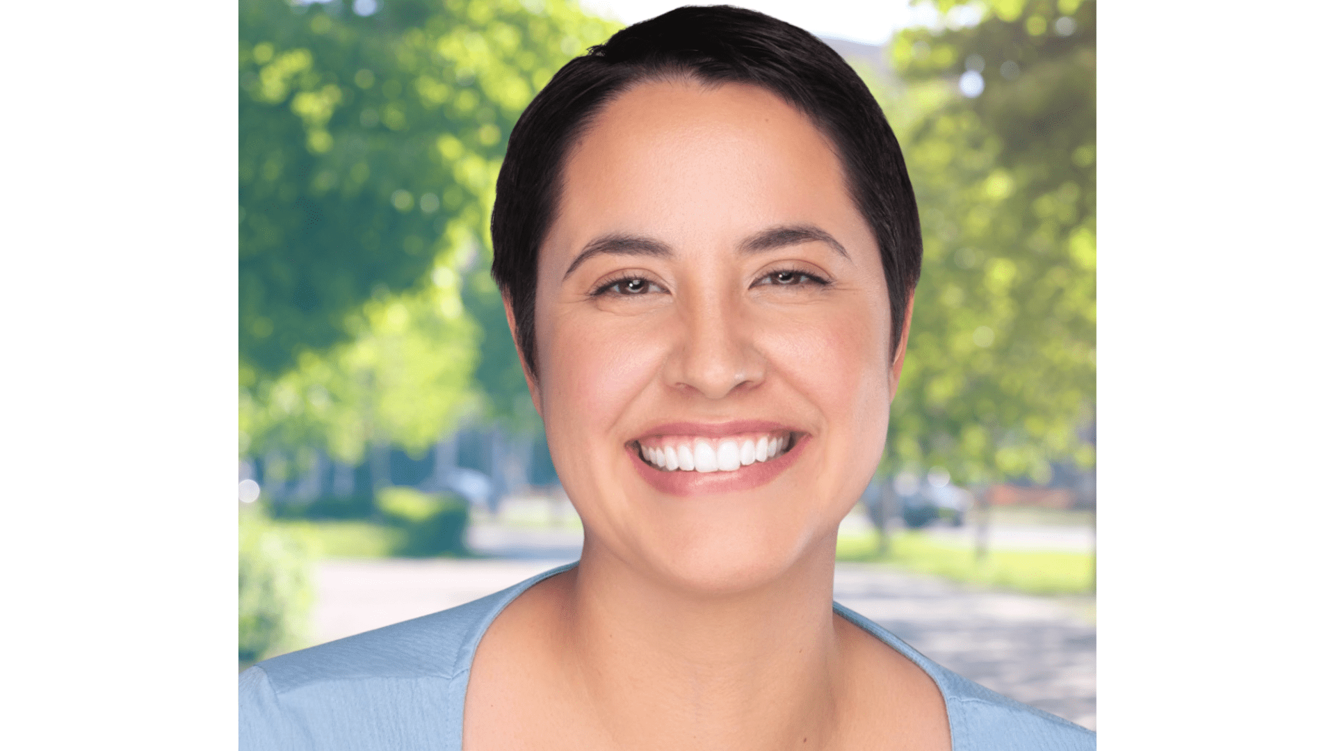 Smiling woman with short hair, outdoors.